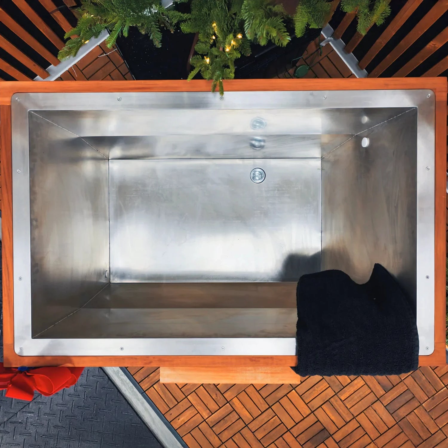 Black cold plunge with stainless steel interior and a wooden trim on the outside