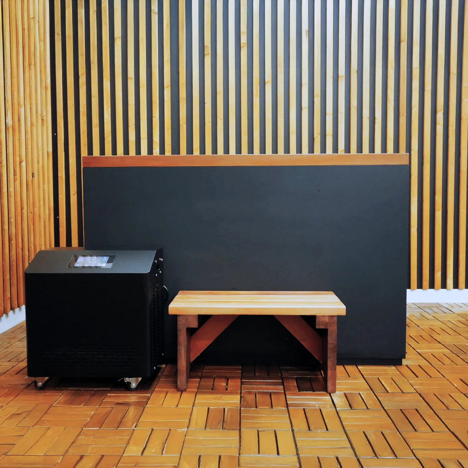 Black cold plunge with a wooden step stool and a black chiller next to it