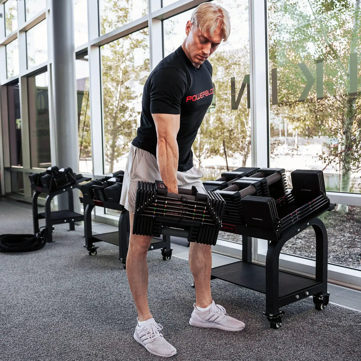 A man removing a dumbbell from a PowerBlock Commercial Pro Max Stand