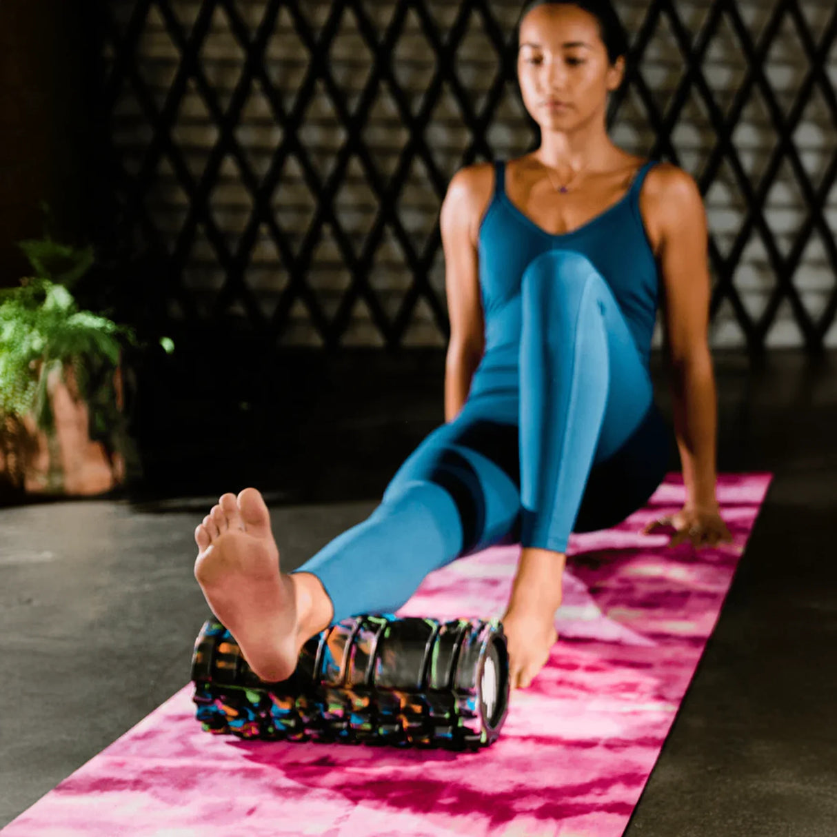 Woman rolling on multi-color tie dye short foam roller