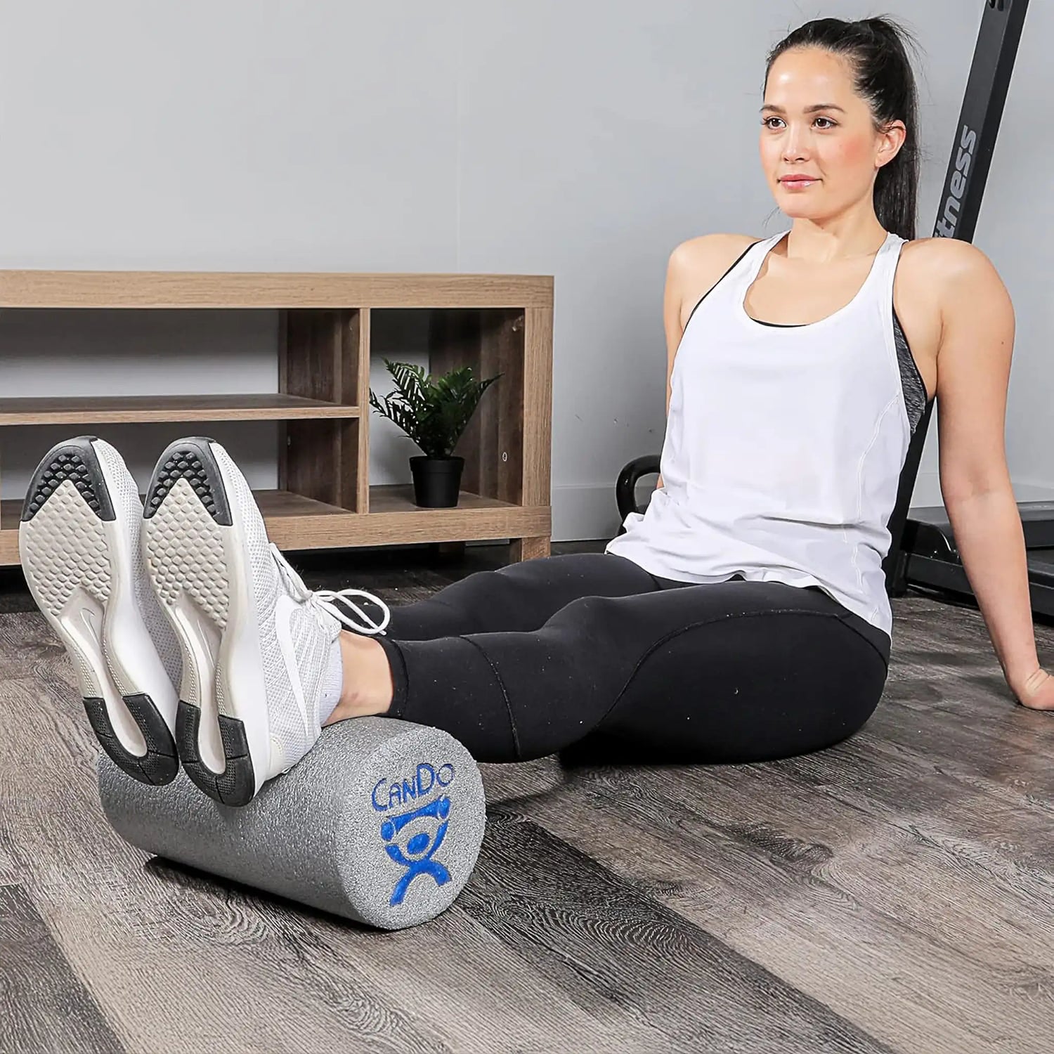 Woman rolling Achilles on open cell foam short foam roller by CanDo