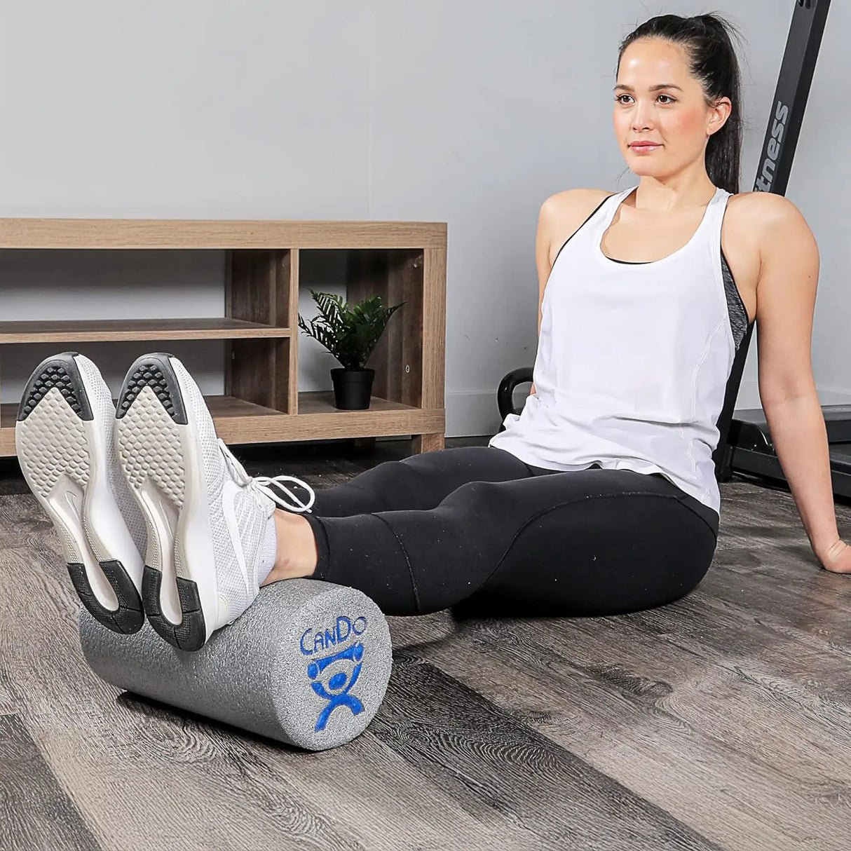 Woman rolling Achilles on open cell foam short foam roller by CanDo