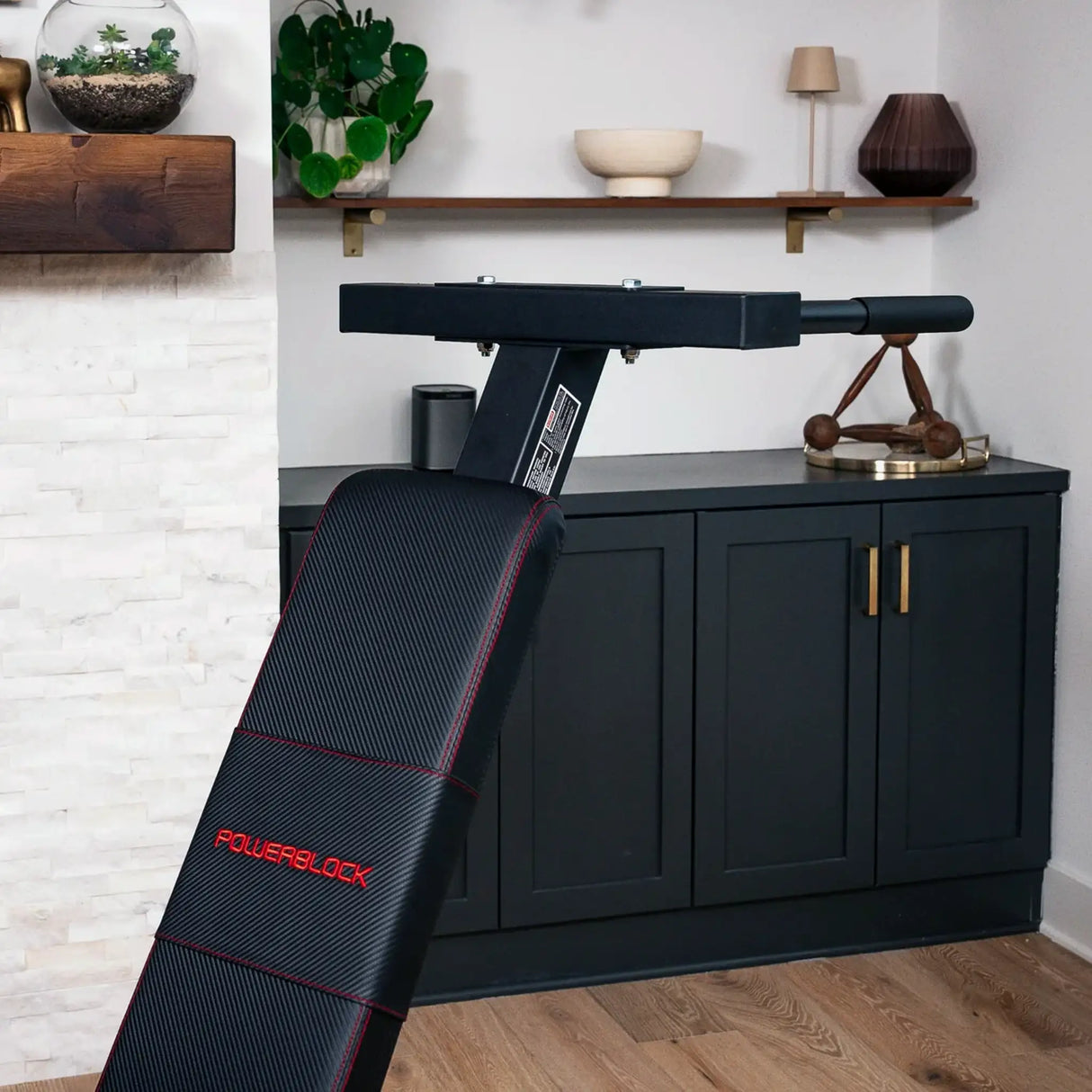 A PowerBlock bench with a dip attachment attached to the back