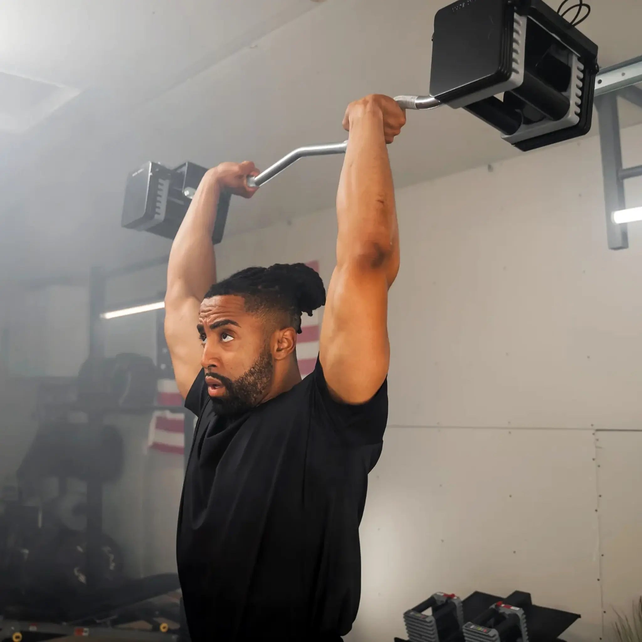 Man pressing a PowerBlock EZ barbell