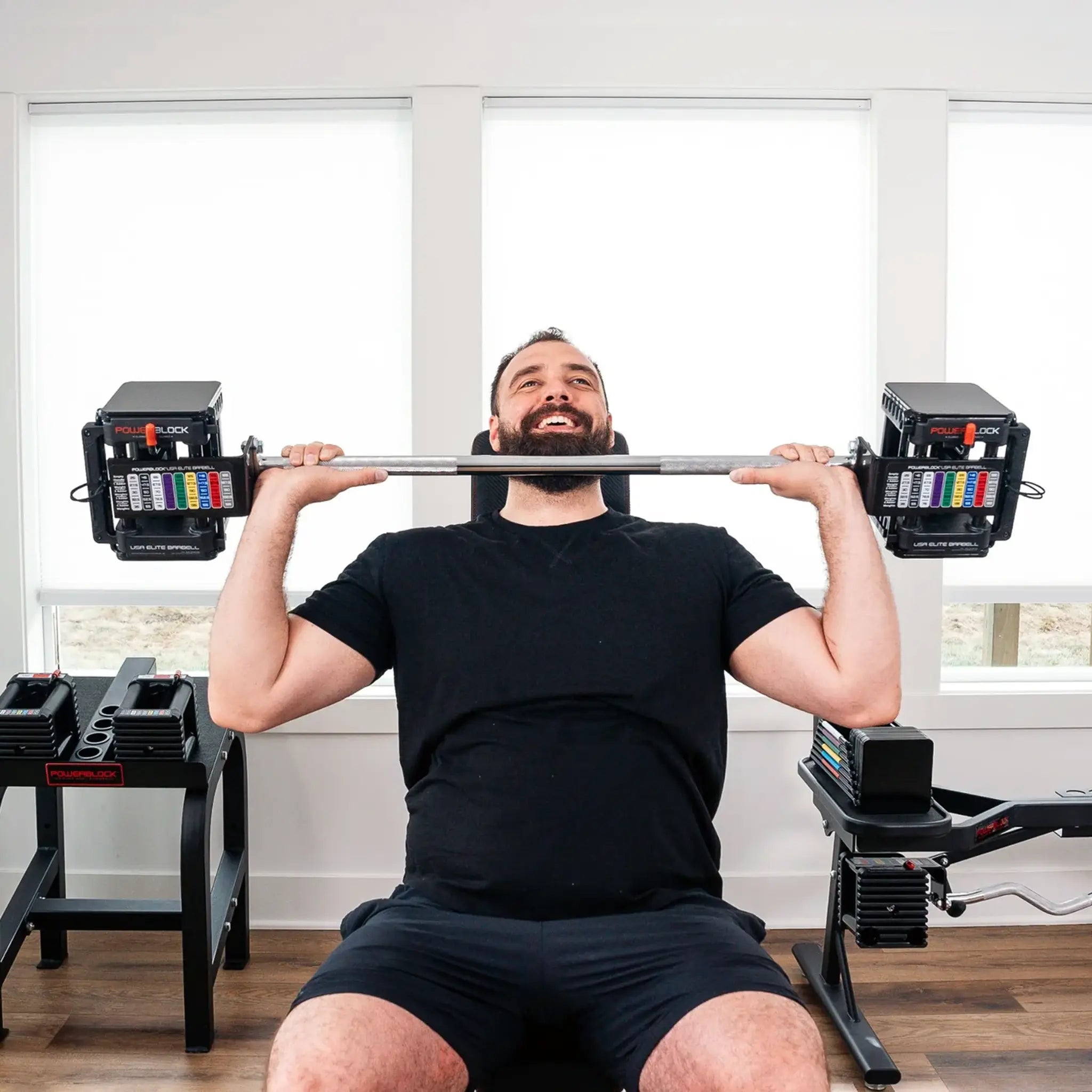 Man pressing a PowerBlock straight barbell