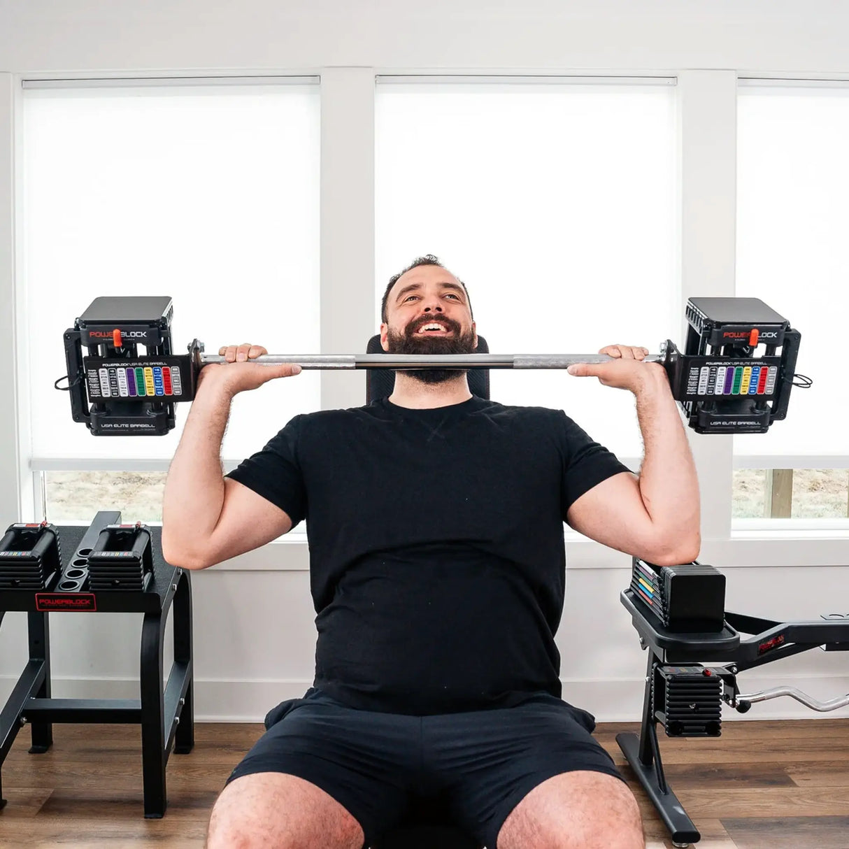 Man pressing a PowerBlock straight barbell