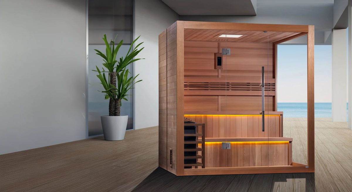 Golden Designs Kuusamo model traditional steam sauna built for indoor or covered outdoor use constructed from Canadian red cedar on the inside and Canadian hemlock on the outside with a six person capacity on a wooden dock overlooking the ocean