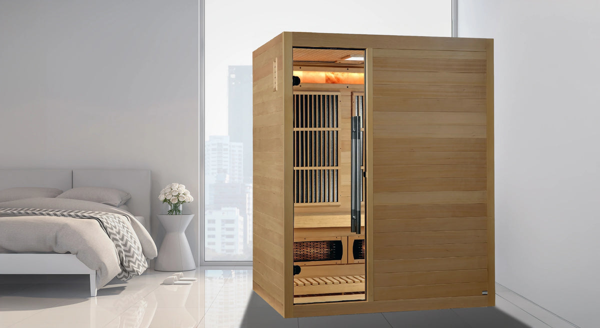Golden Designs Soria hybrid model sauna featuring both full spectrum infrared and traditional steam technology with a three person capacity constructed from Canadian hemlock wood inside a white bedroom
