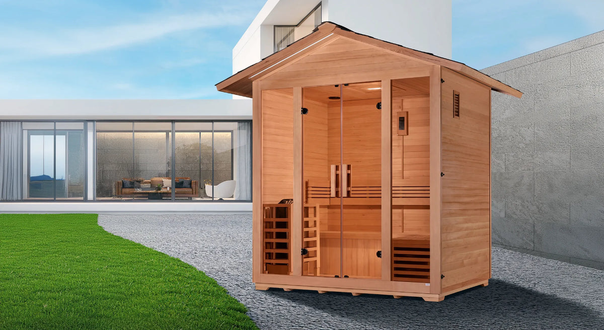 Golden Designs Vorarlberg traditional steam sauna made from Canadian hemlock wood which features a gabled roof and a five person capacity making it great for outdoor use pictured in the back yard of a large home