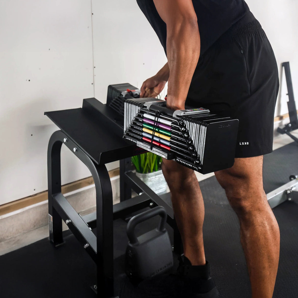 A man removing a dumbbell from PowerBlock Home Rack Stand