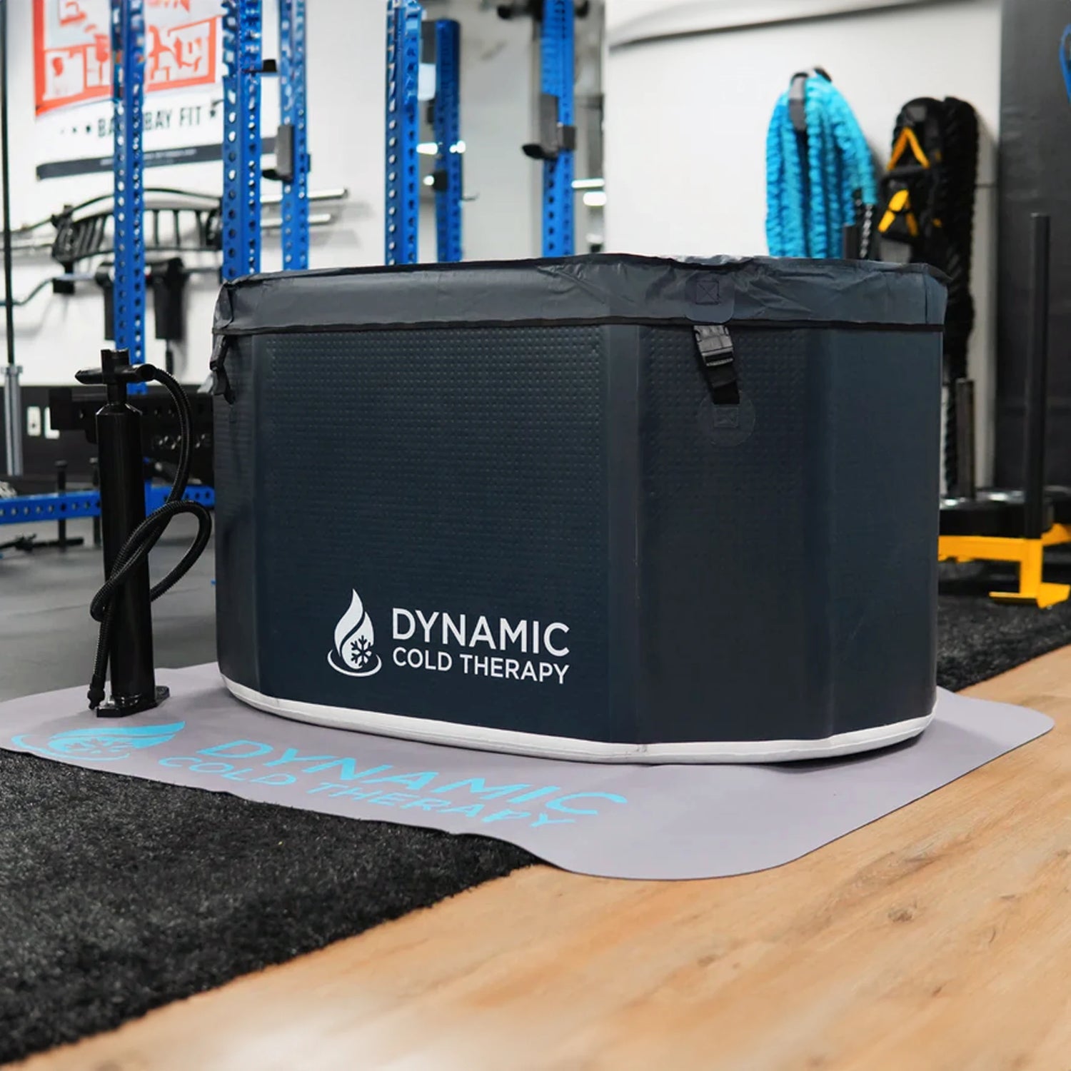 Dark blue inflatable cold plunge tub with a black pump sitting next to it