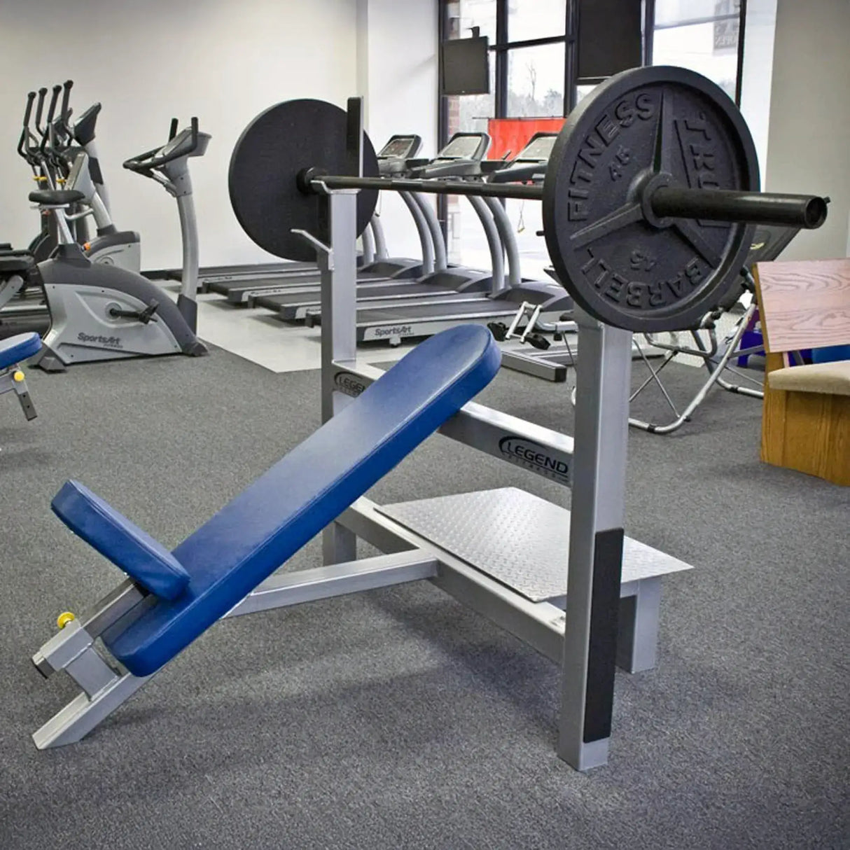 Blue weight bench with barbell in a gym setting