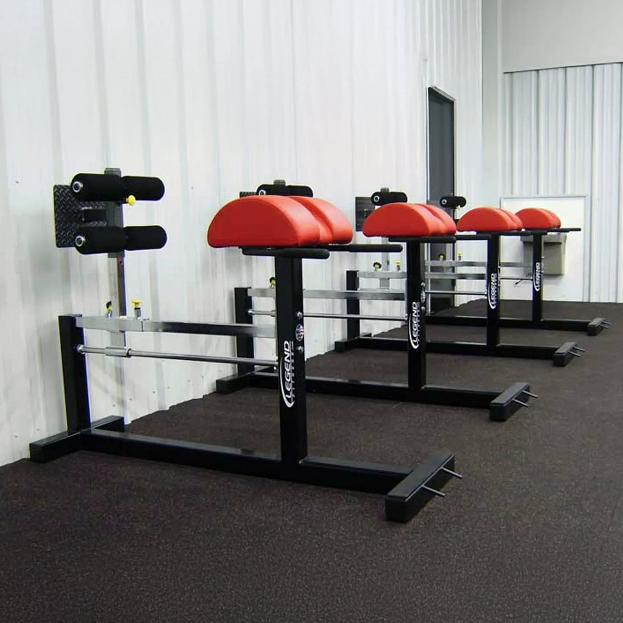 Four black and red glute ham developer fitness machines in a gym setting