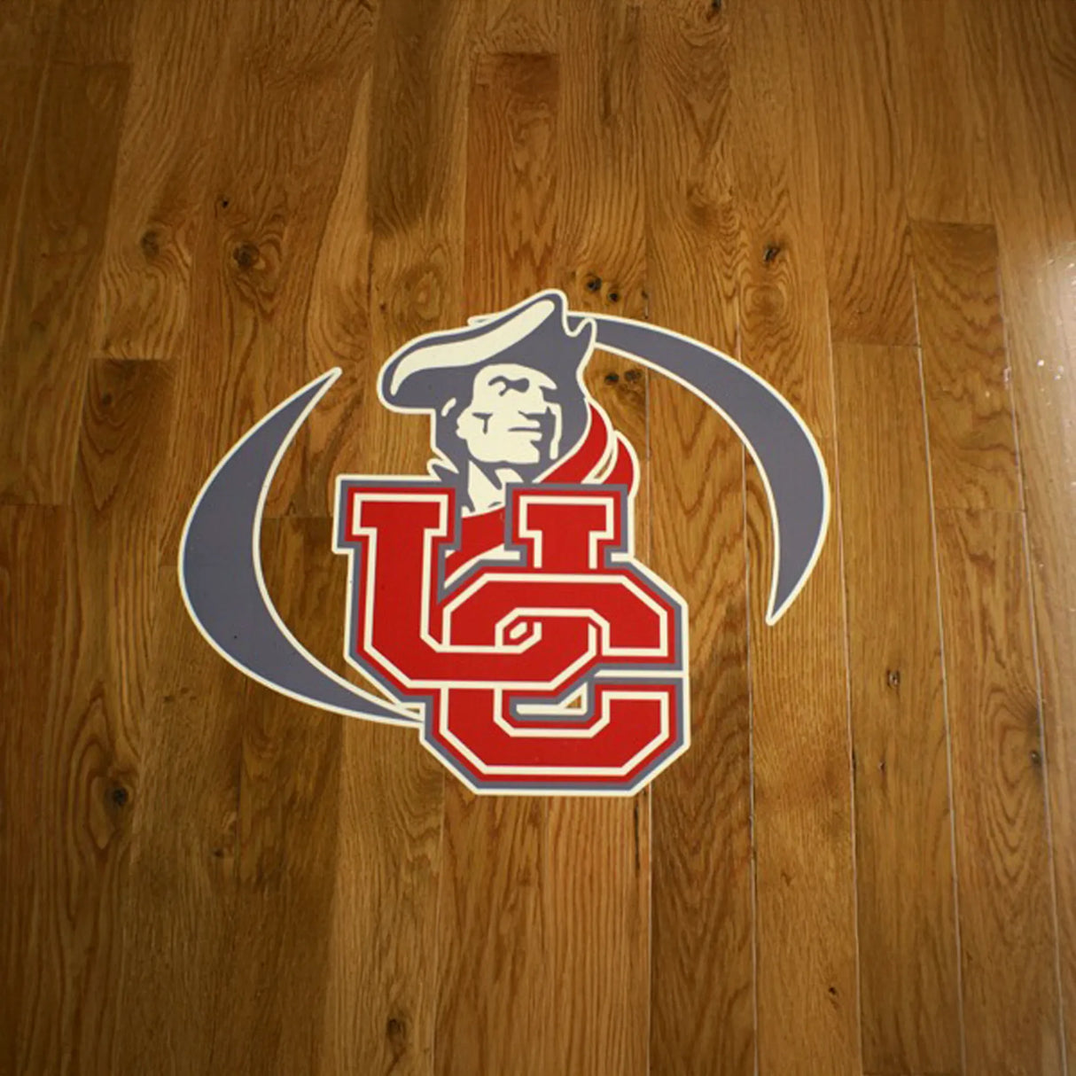 Logo with a stylized 'UC' on a wooden floor background