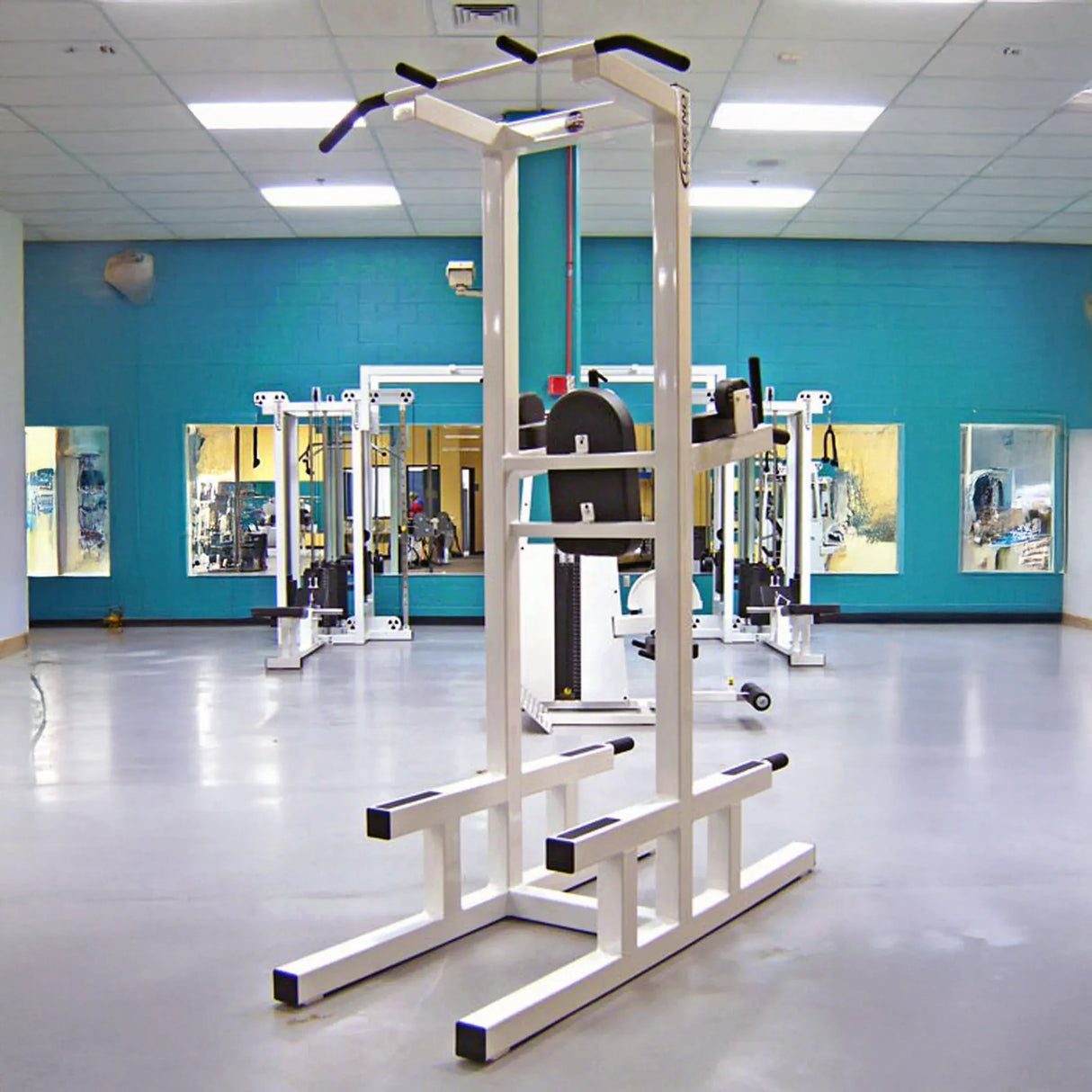 A white pull-up bar and core stand in a gym setting