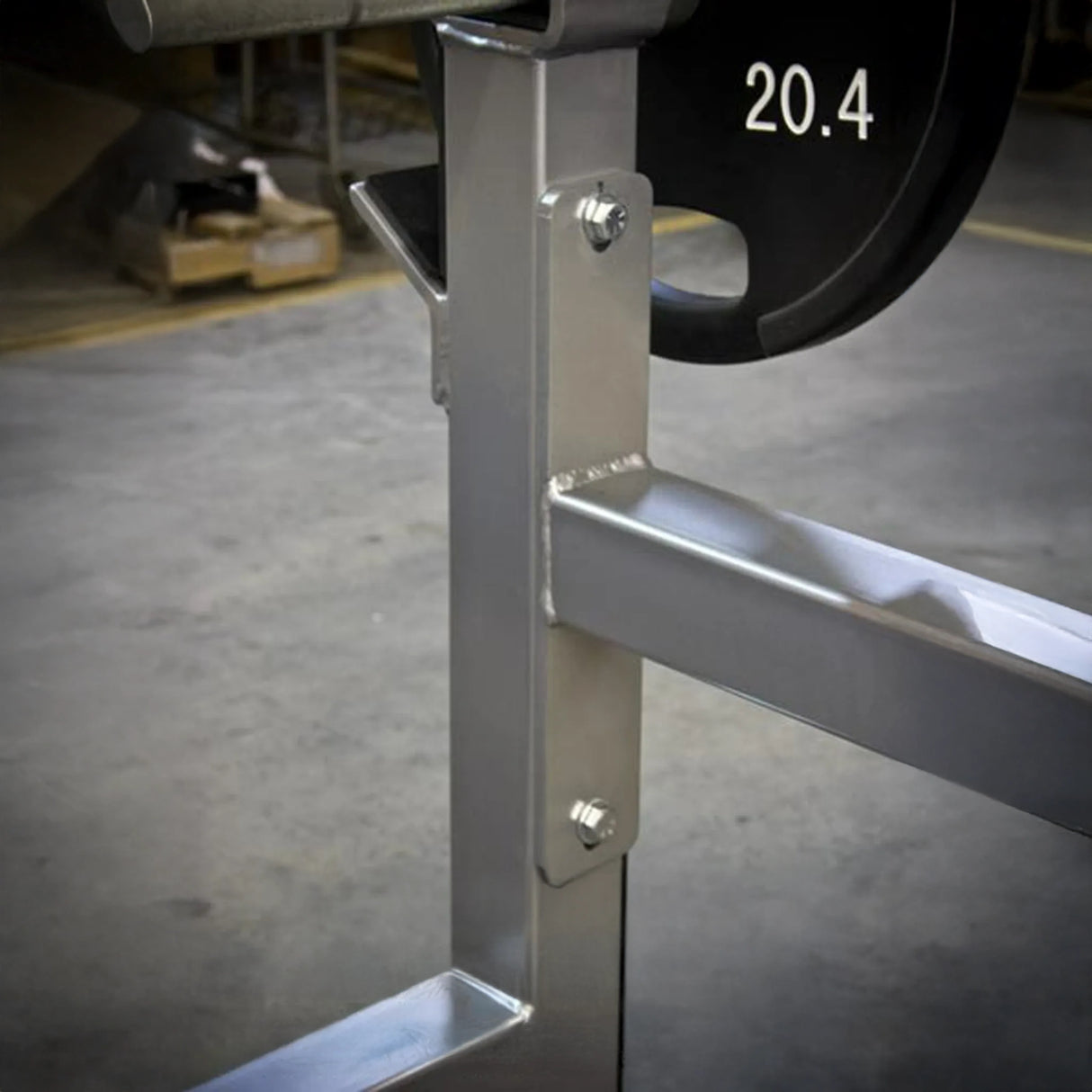 A close-up image of a silver metal frame on a gray concrete floor