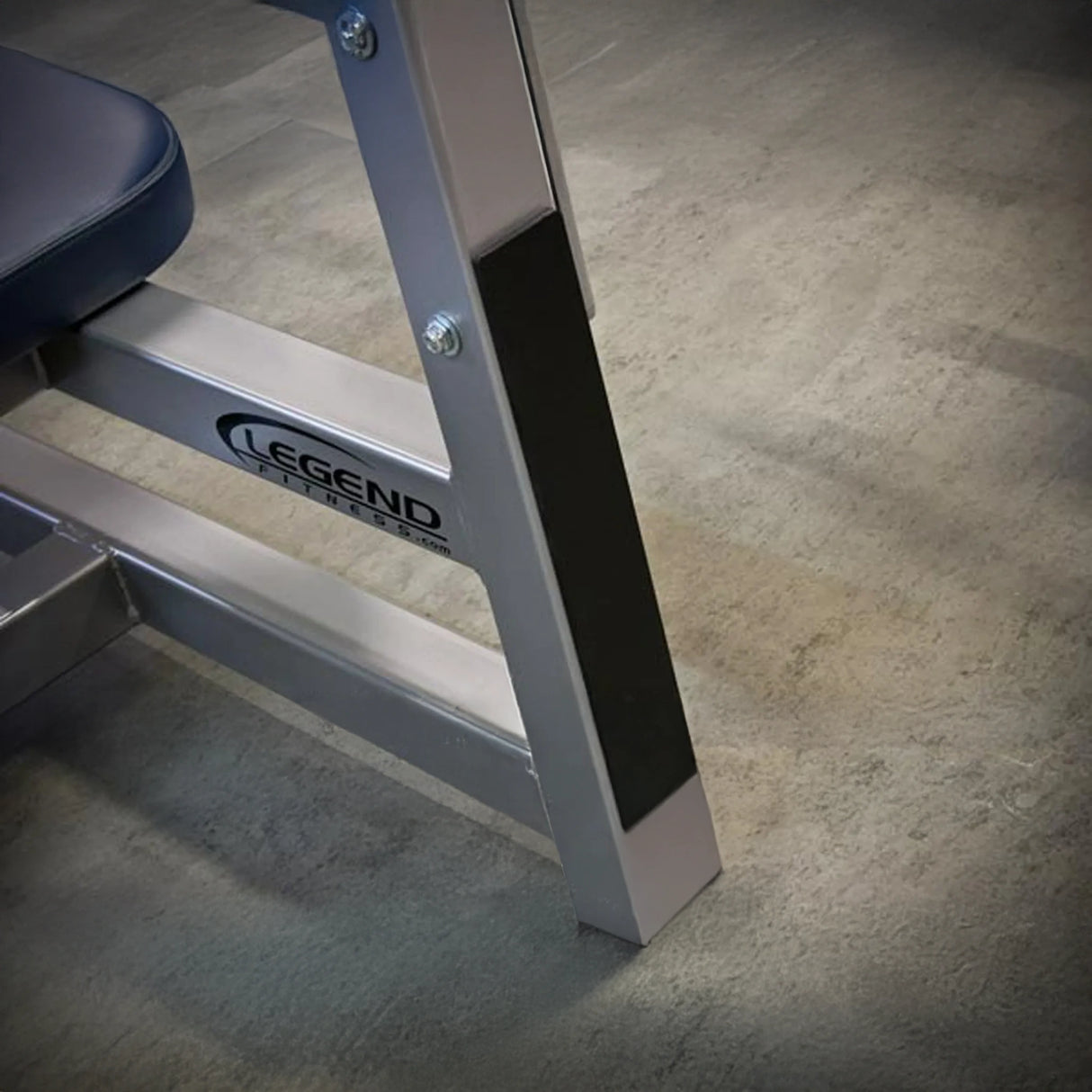 Gym bench with 'Legend Fitness' branding on a concrete floor.
