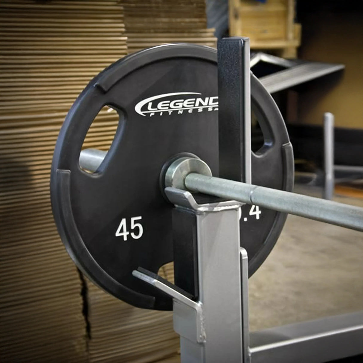 Weight plate with 'Legend Fitness' branding on a barbell