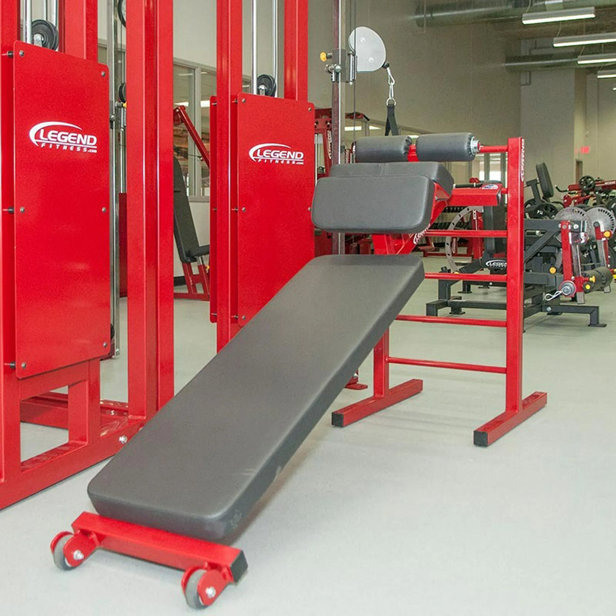 A red and black sit up bench in a gym setting