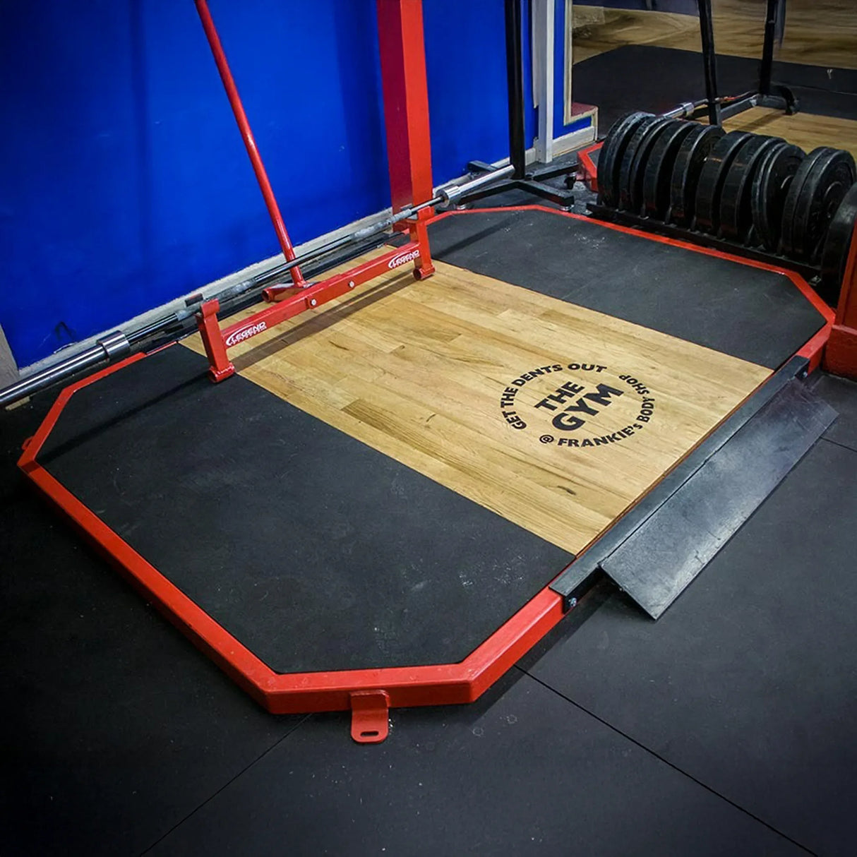 Gym platform with wooden surface and red frame, featuring 'The Gym' branding.
