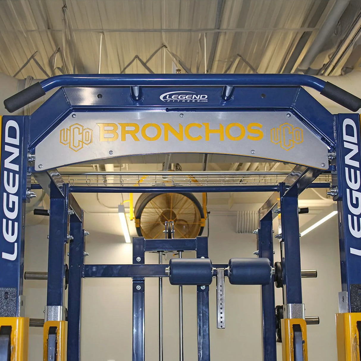 Gym equipment with 'Legend Fitness' branding and 'Bronchos' engraved on a nameplate in a gym setting.