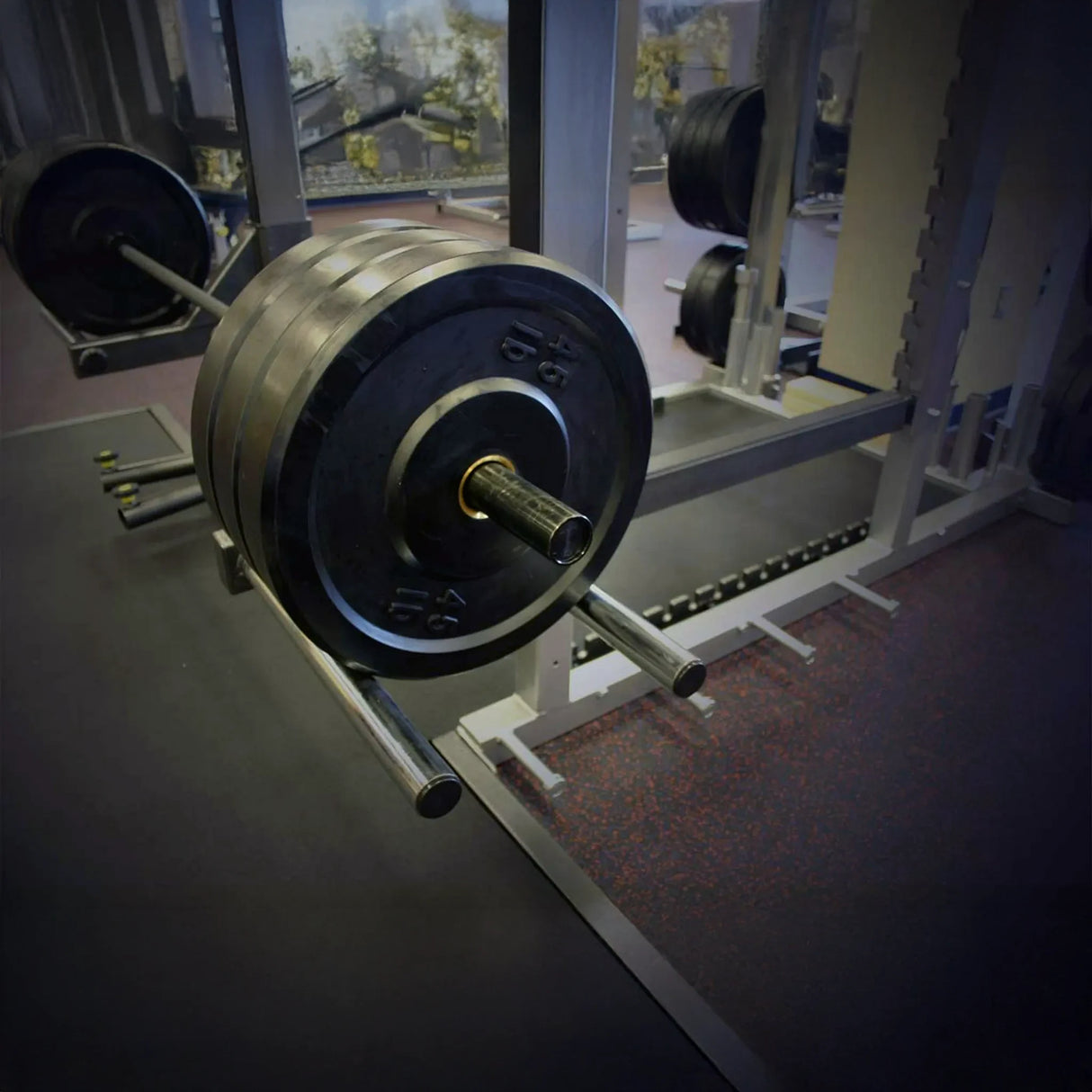 Barbell with weight plates on a rack in a gym setting