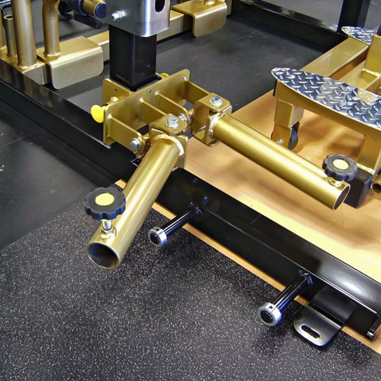 A metal dual landmine attachment mounted to a squat rack