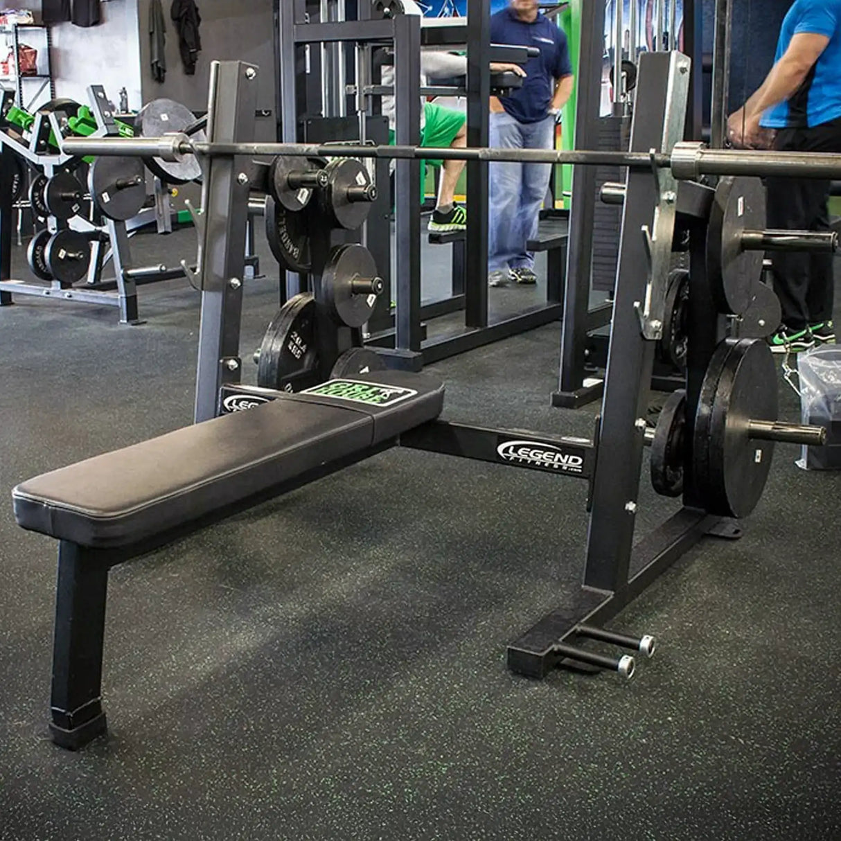 A black Olympic flat bench press in a gym setting