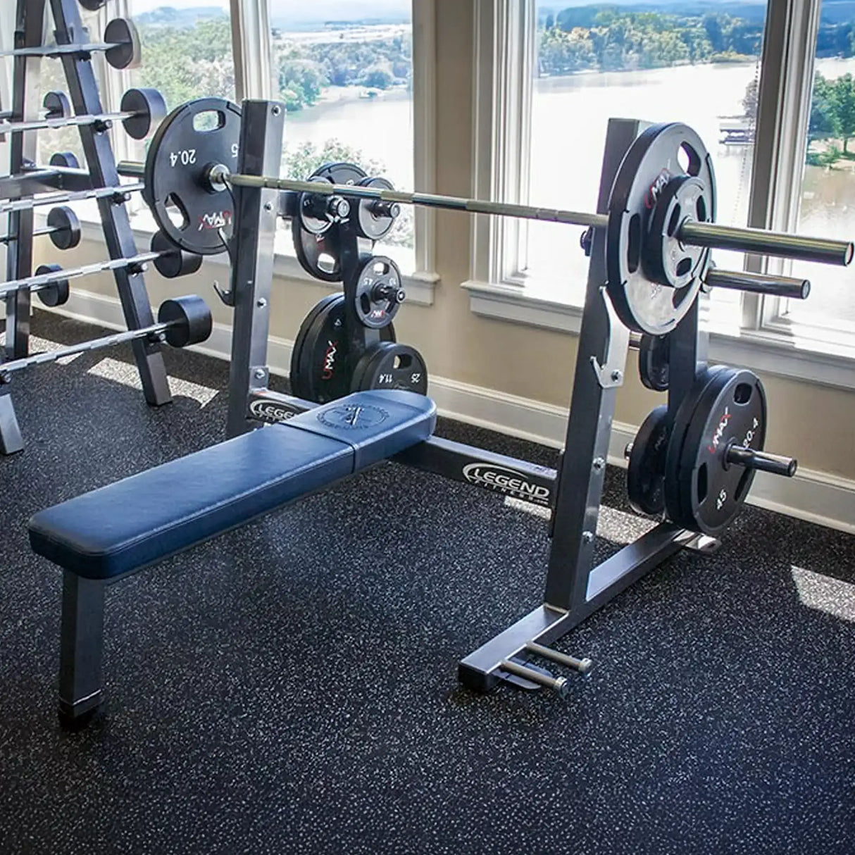 An Olympic flat bench press in a gym setting on a rubber floor