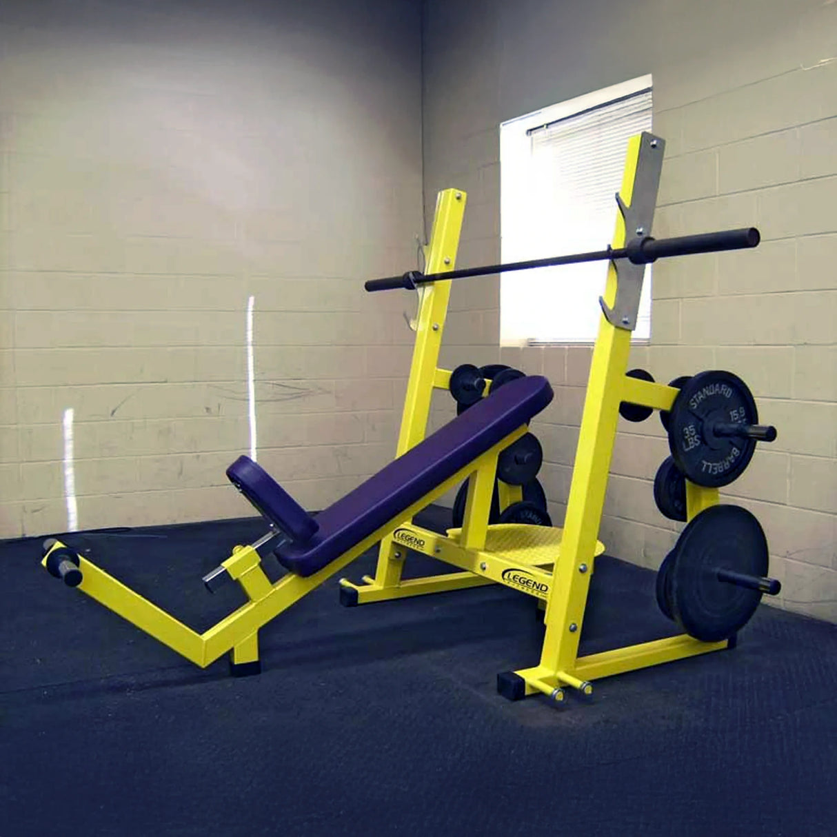 A yellow and purple incline bench press on a blue floor with a white wall in the background.