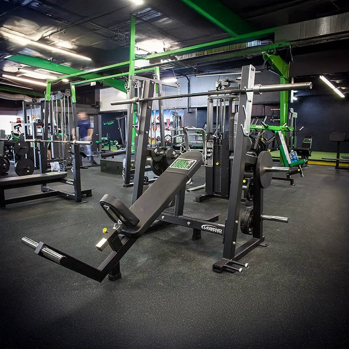 A black incline Olympic bench press in a gym setting
