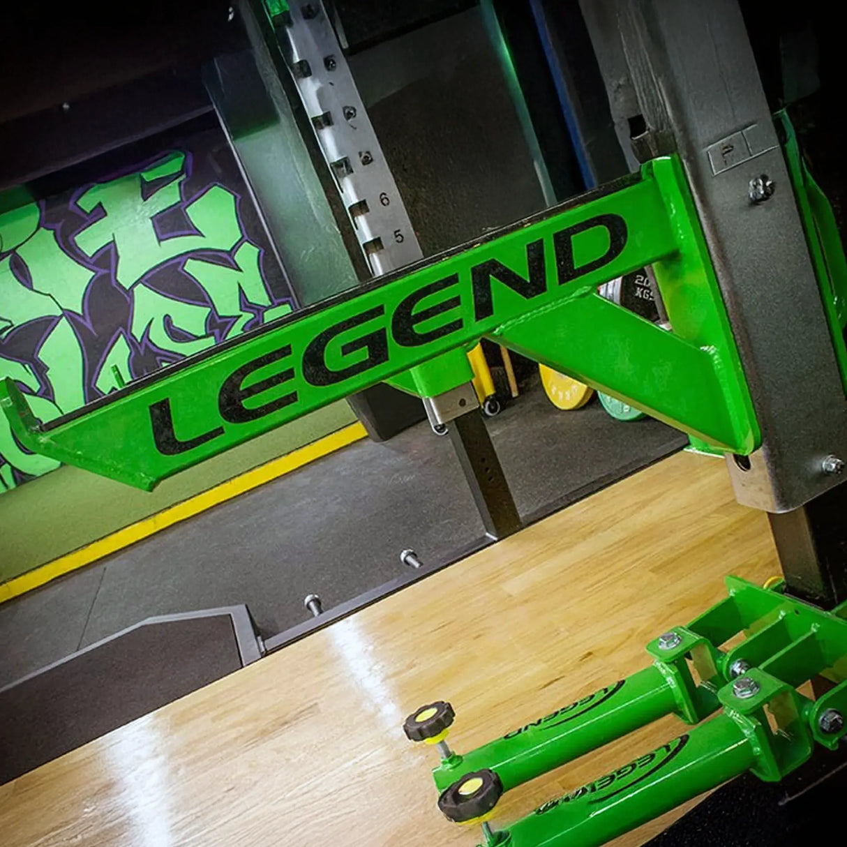 A metal safety arm mounted to a squat rack with 'Legend' branding