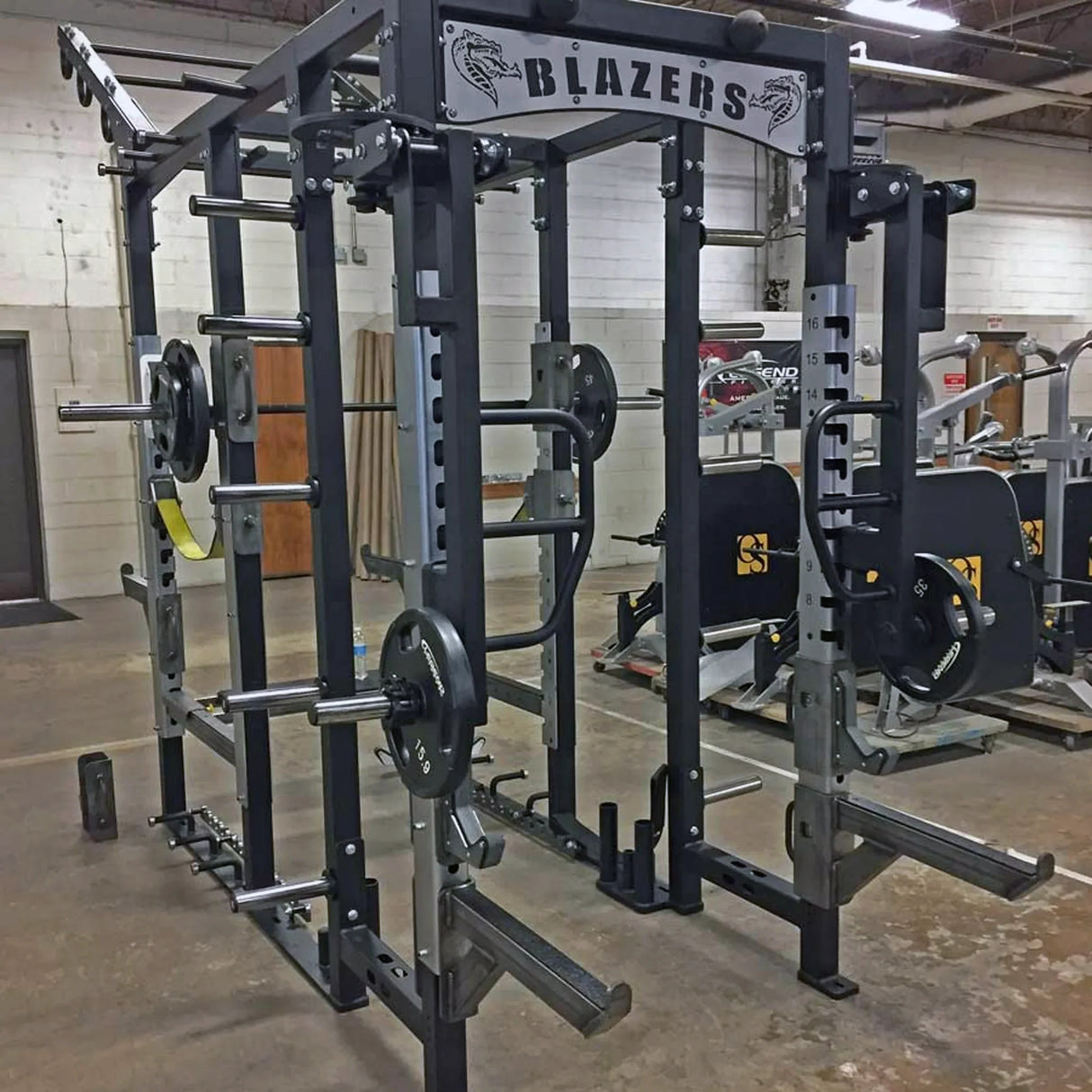 Rotating jammer arms connected to the top of a Legend Fitness weight lifting cage