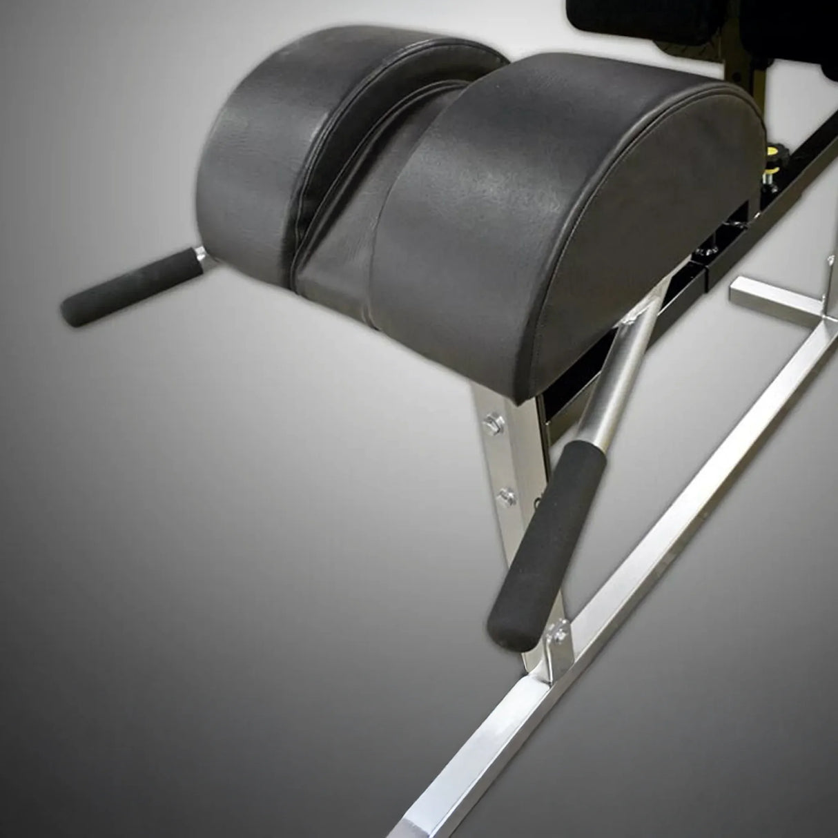 A black upholstered pad on a silver metal frame on a gray background