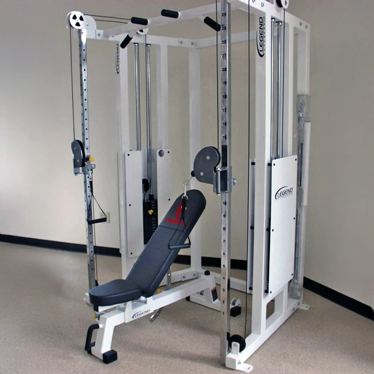 The Legend Fitness 953 Functional Trainer Machine by Legend Fitness, featuring adjustable pulleys and weight stacks, stands in the gym with a padded adjustable bench inside for versatile strength exercises.
