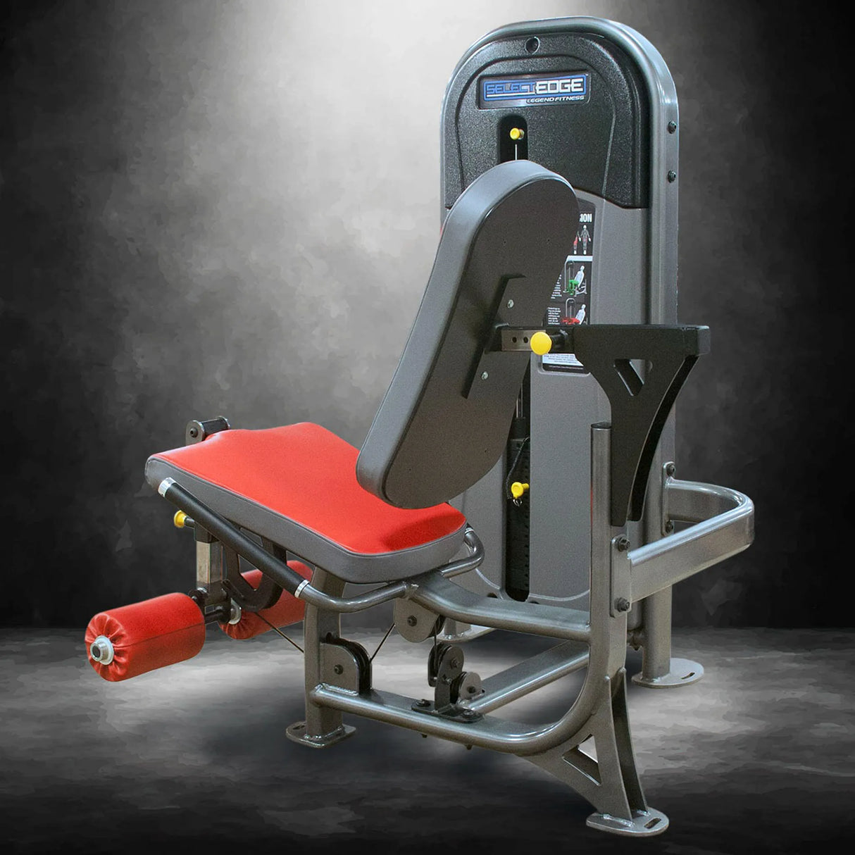 Gym machine with red seat and gray frame on a dark background