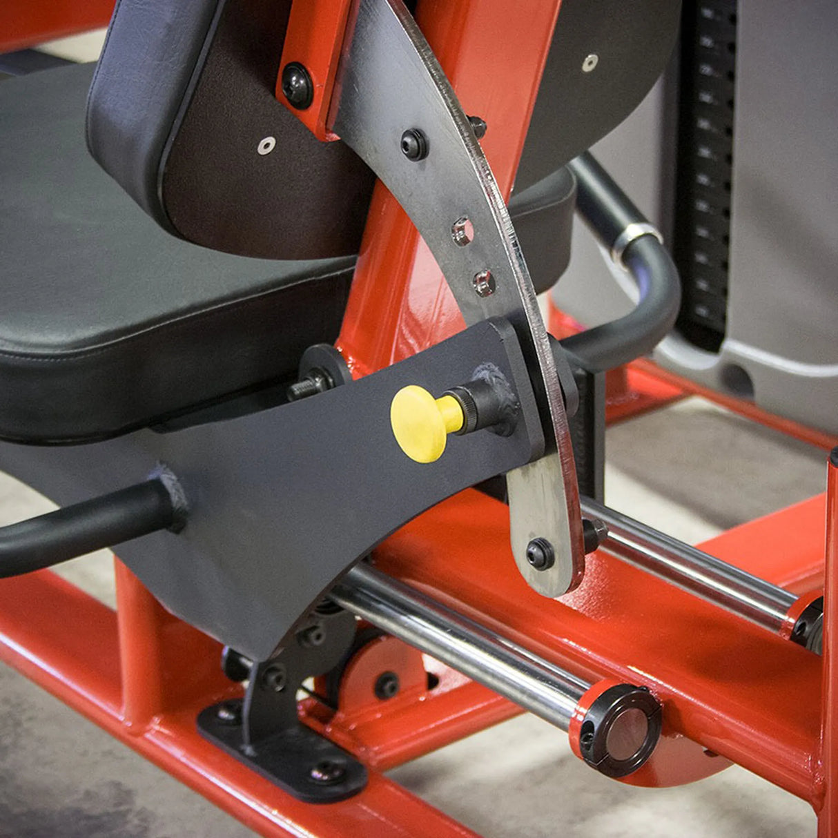 Close-up of a red and black piece of exercise equipment with a yellow pop-pin.