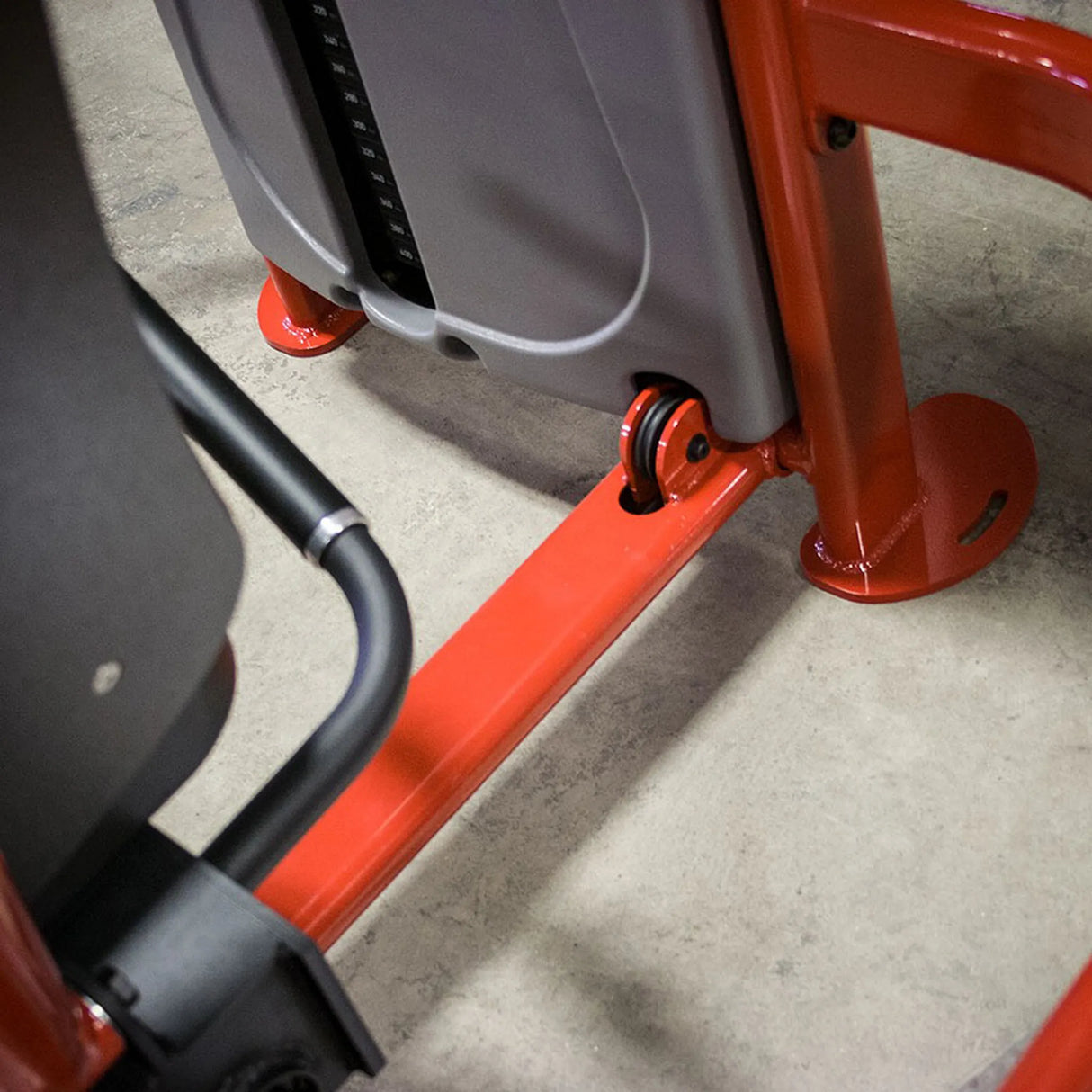 Close-up of a red and gray piece of equipment on a concrete floor