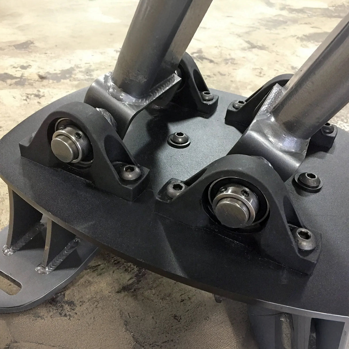 Close-up of a mechanical component with metal bearings on a concrete surface