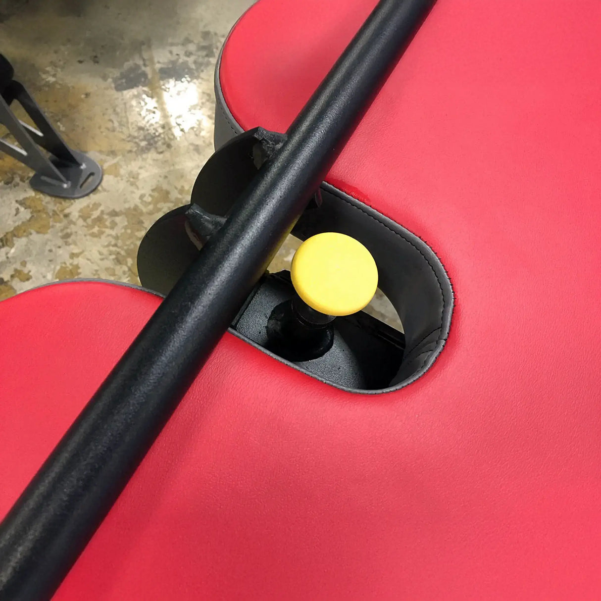 Close-up of a red bench seat with black and yellow components