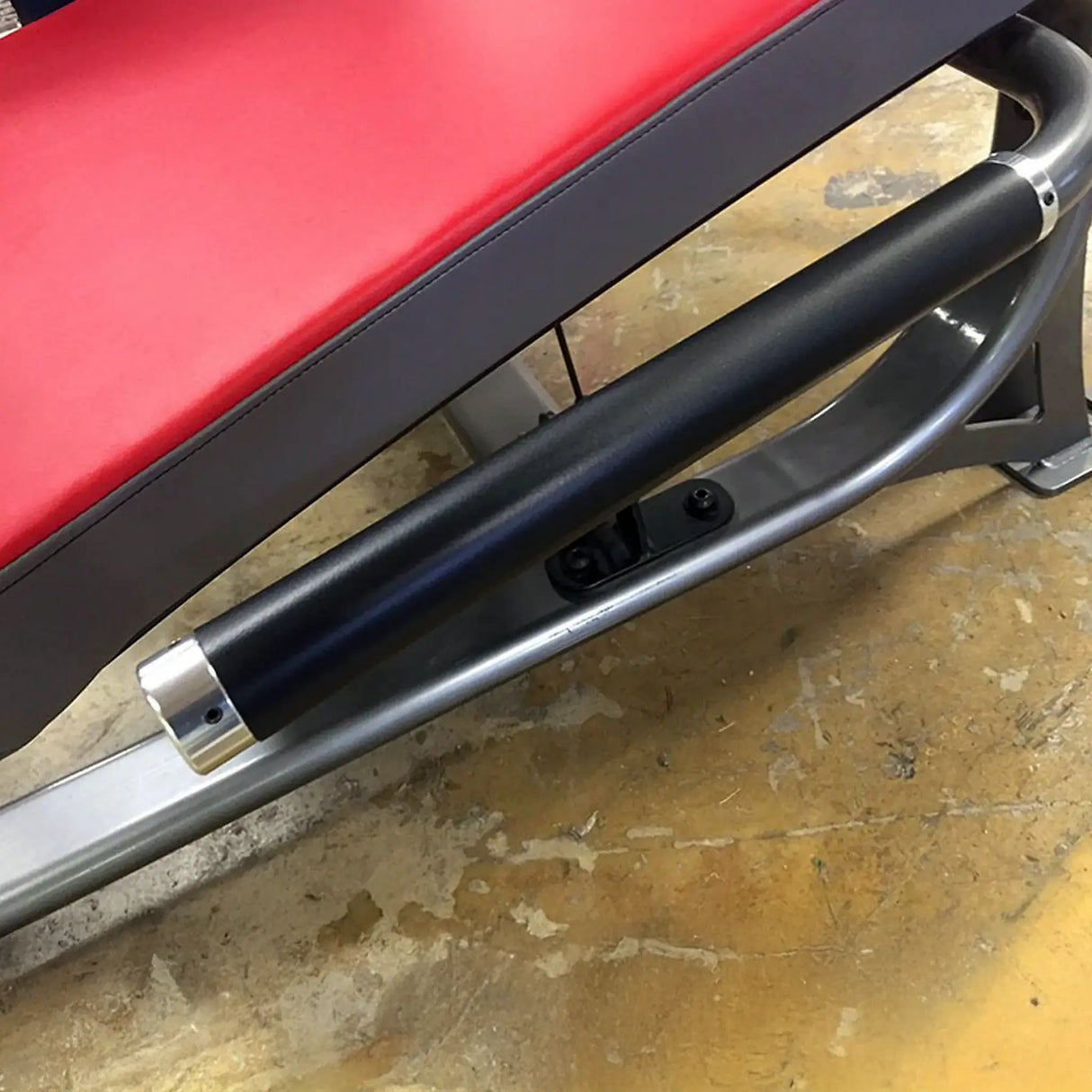 Red and black adjustable weight bench on a concrete floor