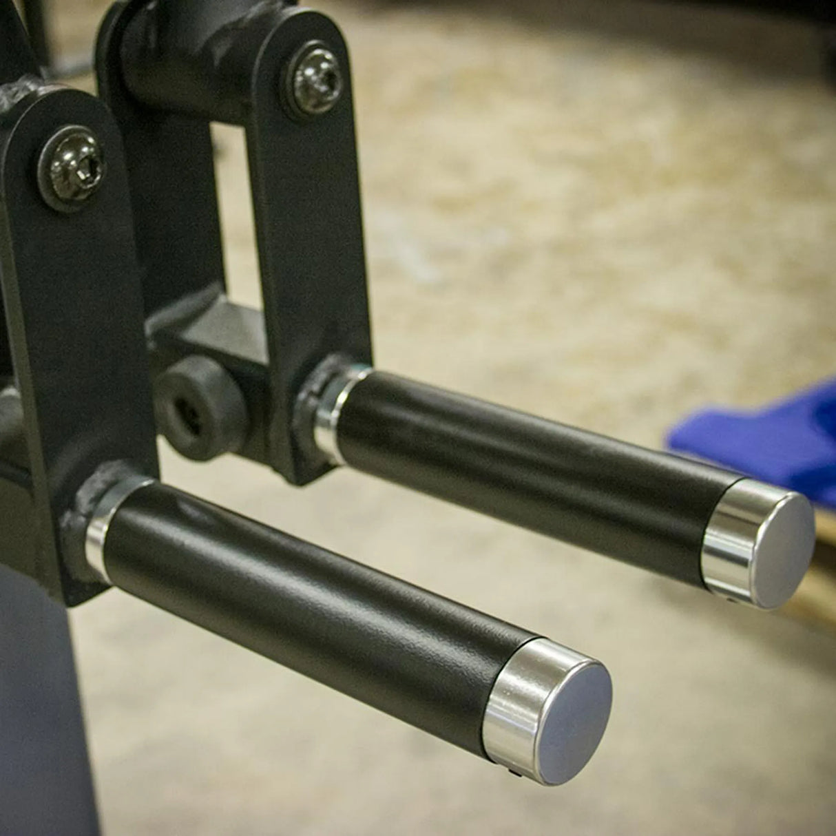 Close-up of two black metal handles with silver ends on a blurred background