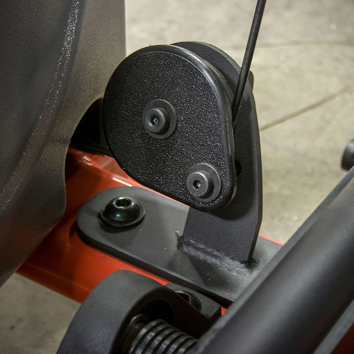 Close-up of a black pulley system on a piece of machinery.