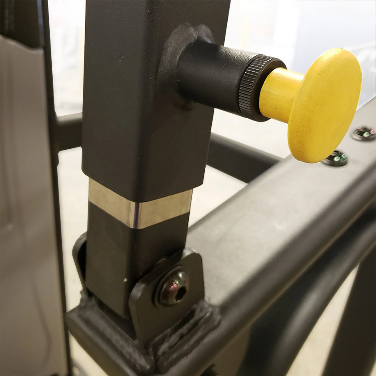 Closeup of a yellow pull-pin on a black piece of fitness equipment