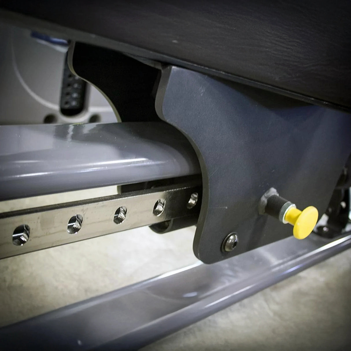 Close-up of a mechanical component with a yellow pop-pin on a metallic surface.