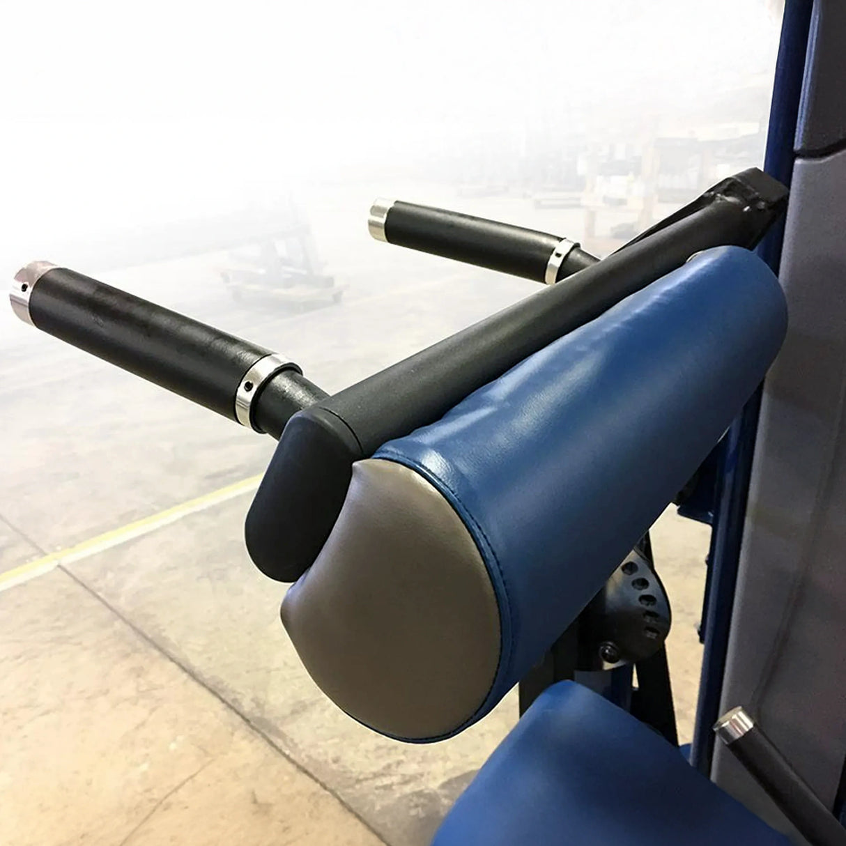 Closeup image of black framed gym equipment with blue padding