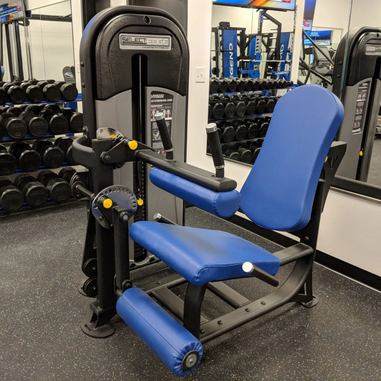 Blue and black gym machine in a fitness center with weights in the background