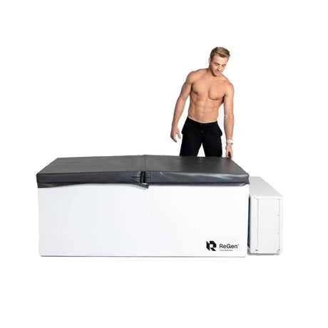 A white rectangular cold plunge with a black foam cover on top and a man standing next to it