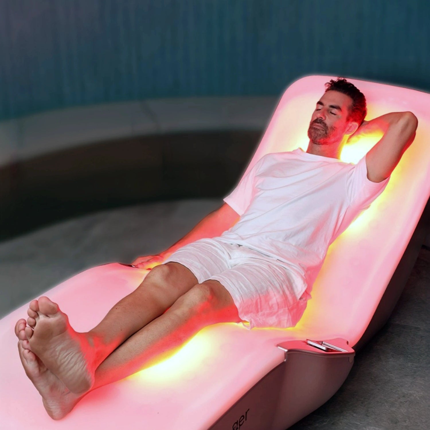 Man lying on red light infrared therapy bed