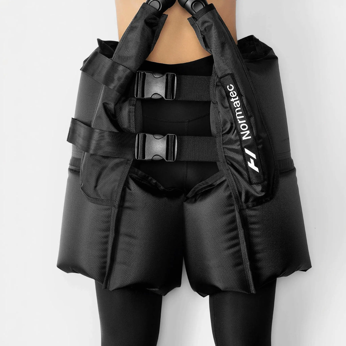 A pair of Normatec Hip Attachments for compression and massage, primarily black in color with branding visible.